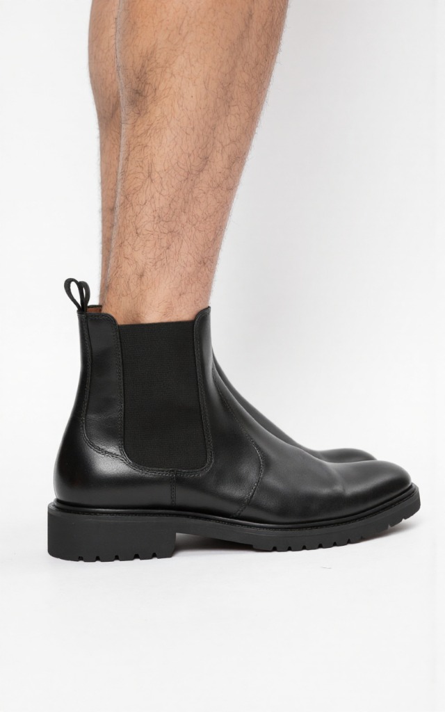 A male model wearing Ankle boots, against a white background, with a close   up of the feet